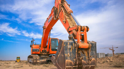 Image of an excavator, an example of a machine produced by heavy equipment manufacturers, on a construction site.