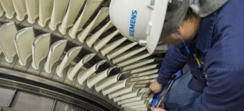 Engineer inspecting gas turbine blades for AM repair