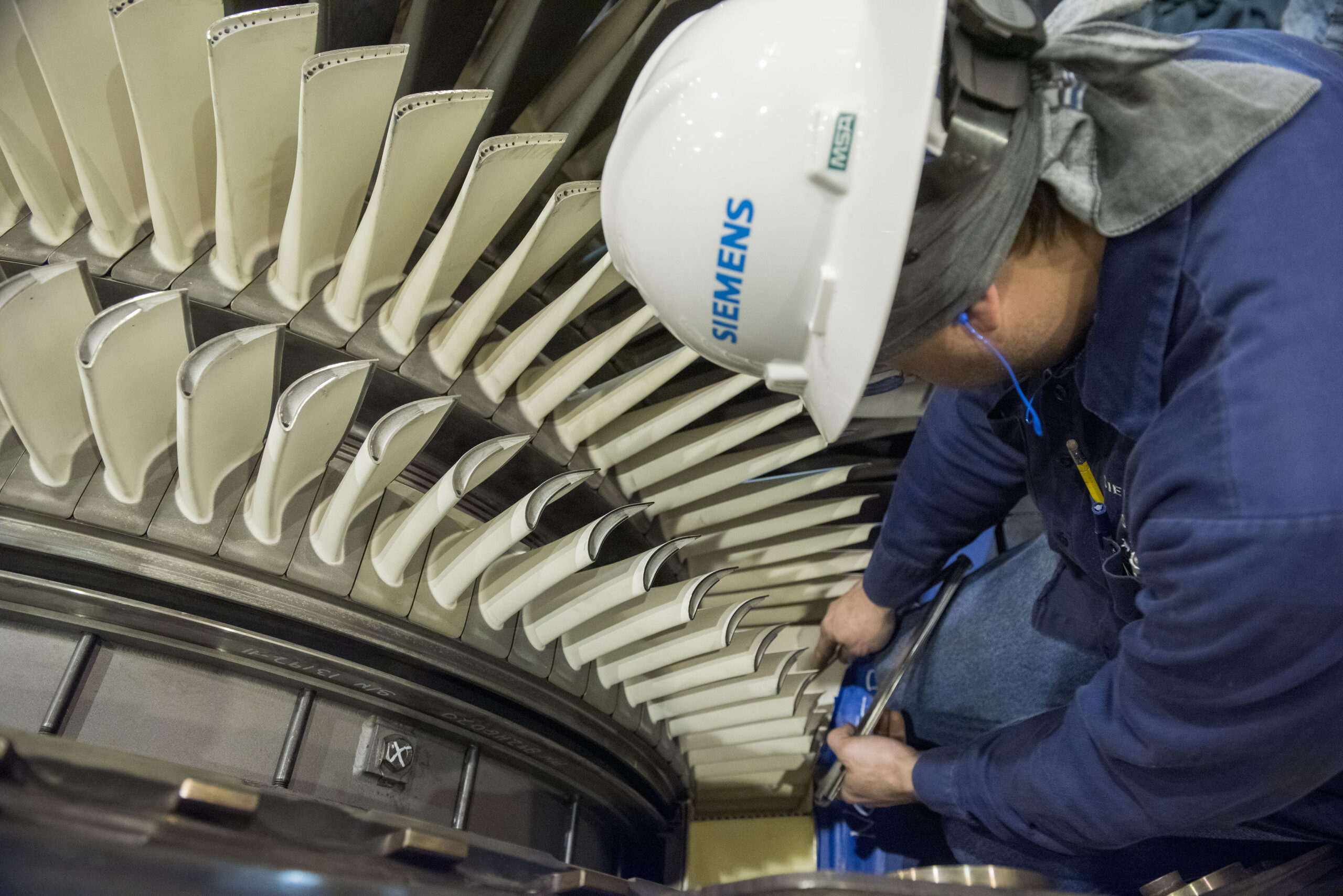 Engineer inspecting gas turbine blades for AM repair