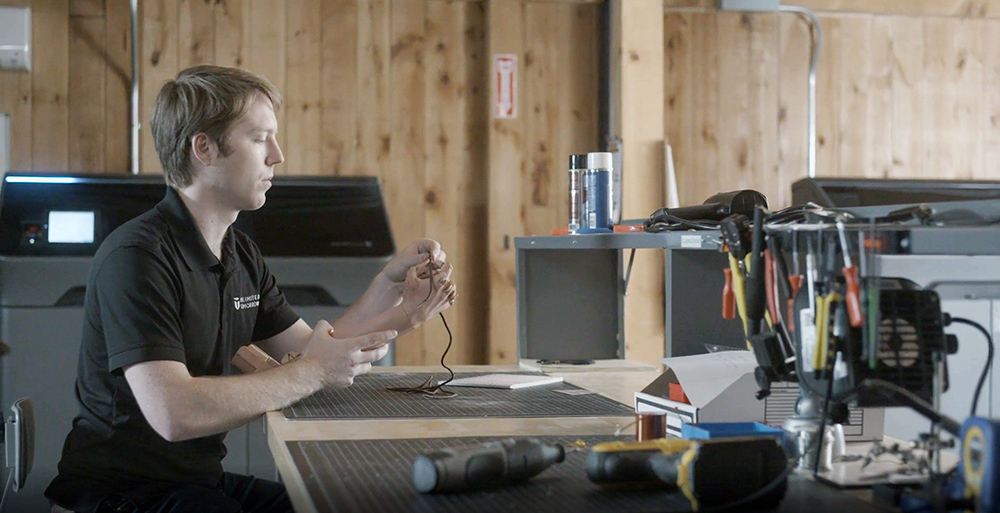 Working on a personalized prosthetic arm at a workbench