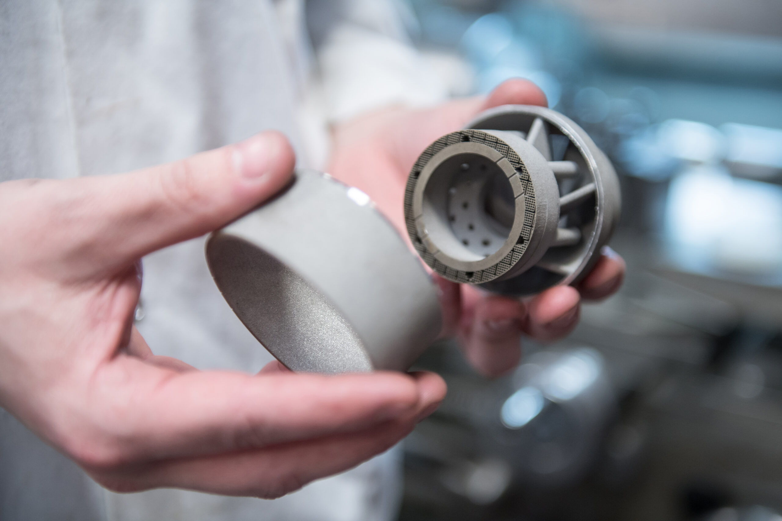 A 3D printed gas turbine part being held.