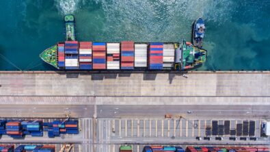 Aerial view of a container ship docked alongside a harbor.