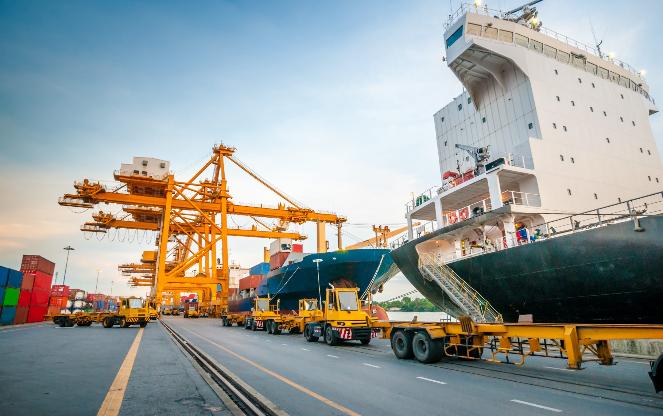 Container ship in a harbor being serviced by cranes.