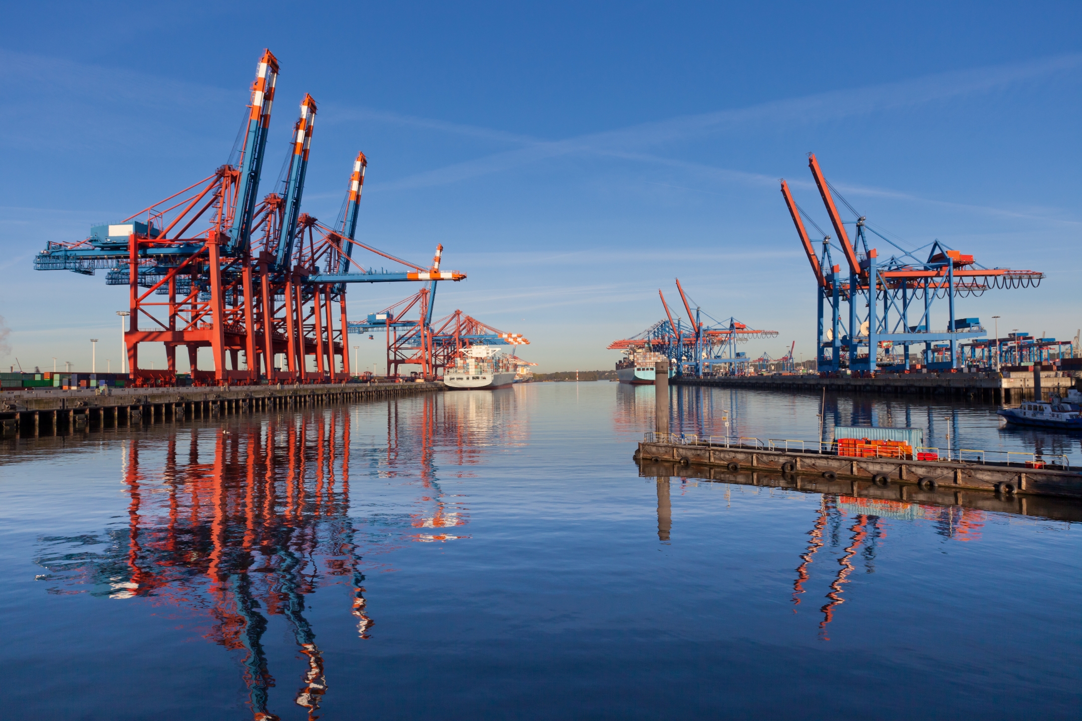 Two lines of cranes standing over a harbor.