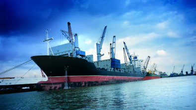 A container ship docked alongside a harbor.