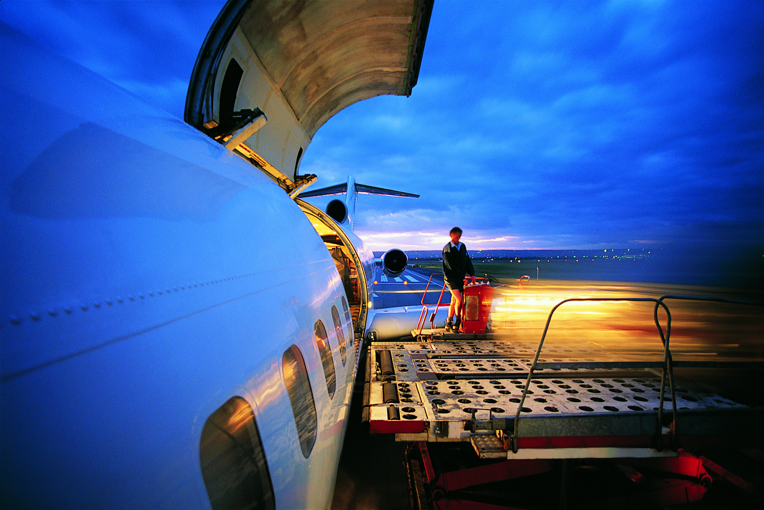 A time-lapsed photo of cargo being offloaded from an airplane.