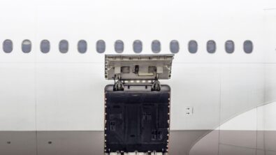 The side of a passenger airplane with the luggage compartment door open.