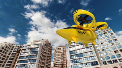 A yellow eVTOL air taxi flying in front of a city.