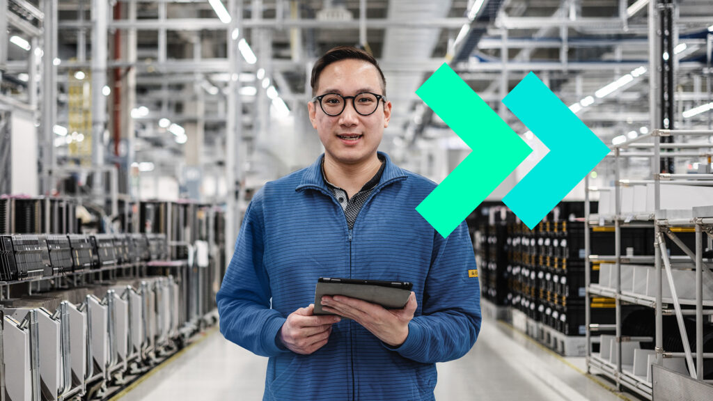 A person on a shop floor with a graphic behind him.