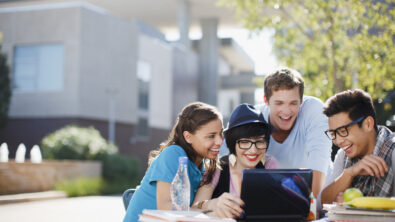 Students using laptop together outdoors