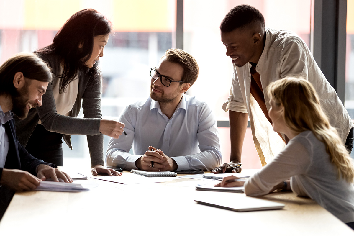 A professional services team collaborates around a table in an office.