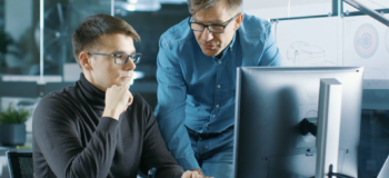 two people looking at a computer collaborating using software tools