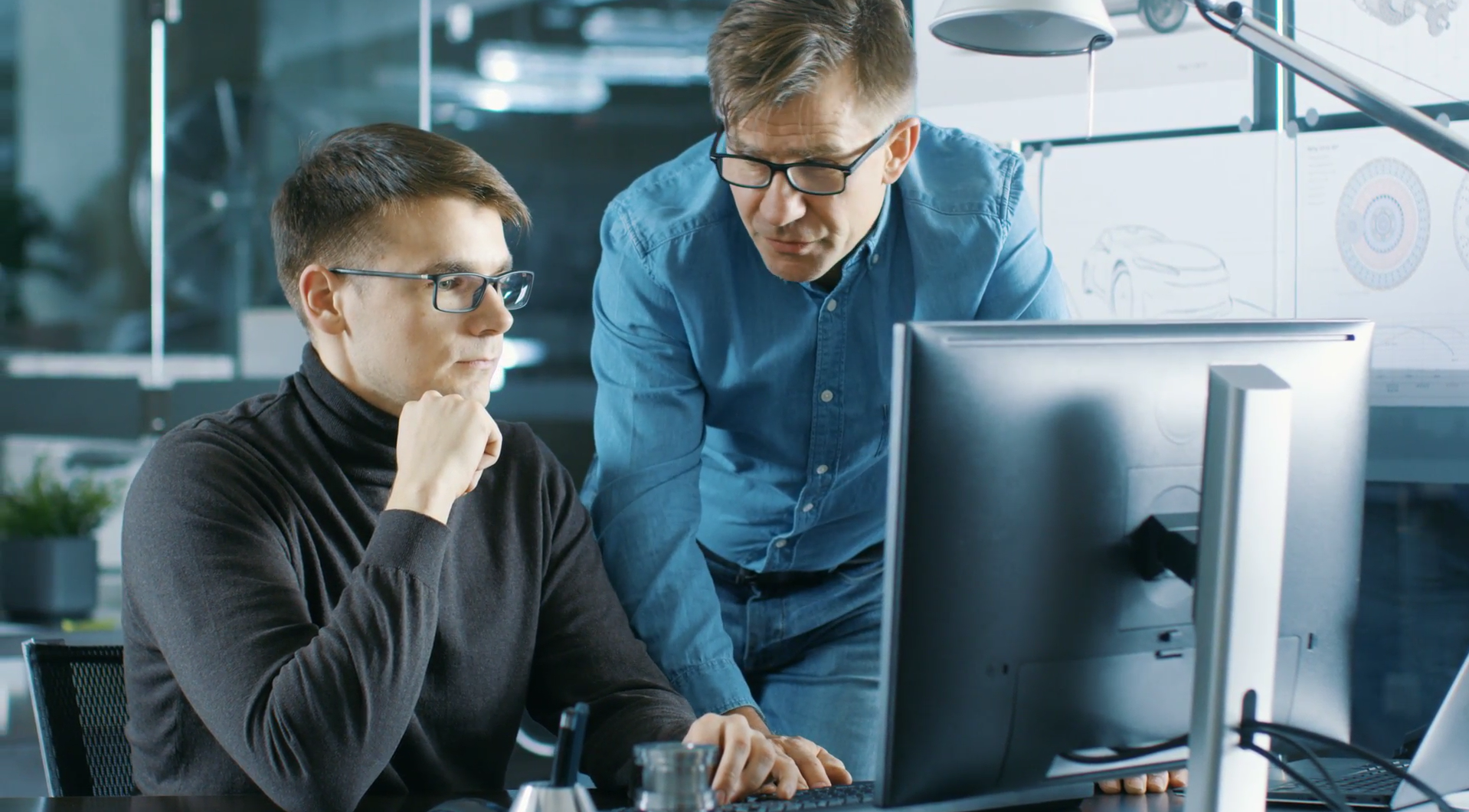 two people looking at a computer collaborating using software tools