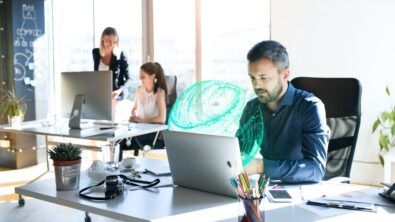 man sitting at a desk working on embedded software