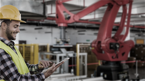 A field service technician uses a tablet to assess industrial machinery.