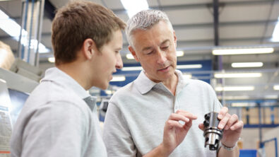 Two engineers inspect a machine component