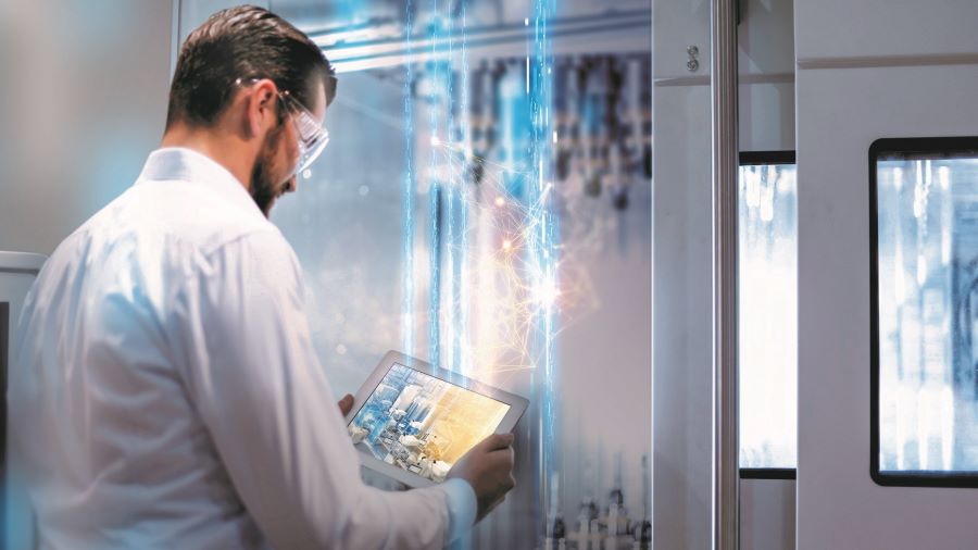 Lab personnel starring at tablet in a manufacturing area