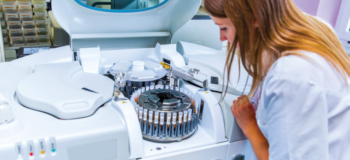 White female looking at test samples in an incubator