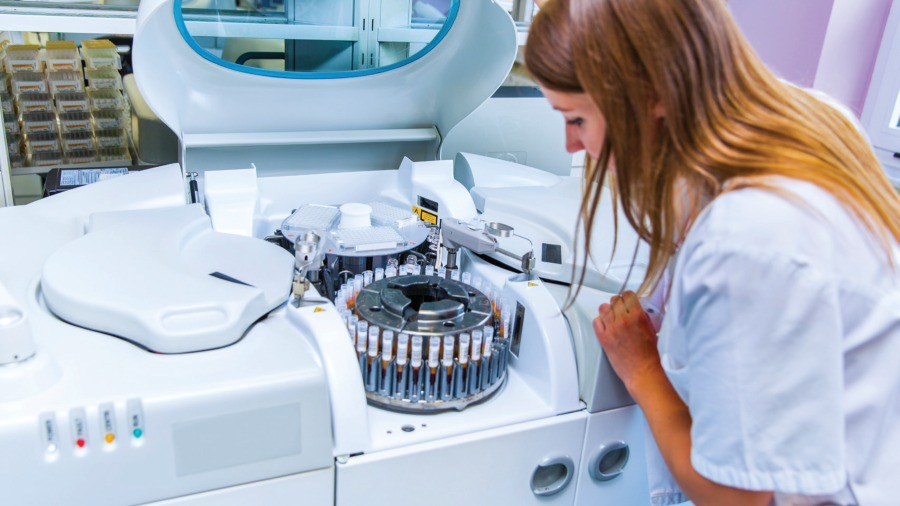 White female looking at test samples in an incubator