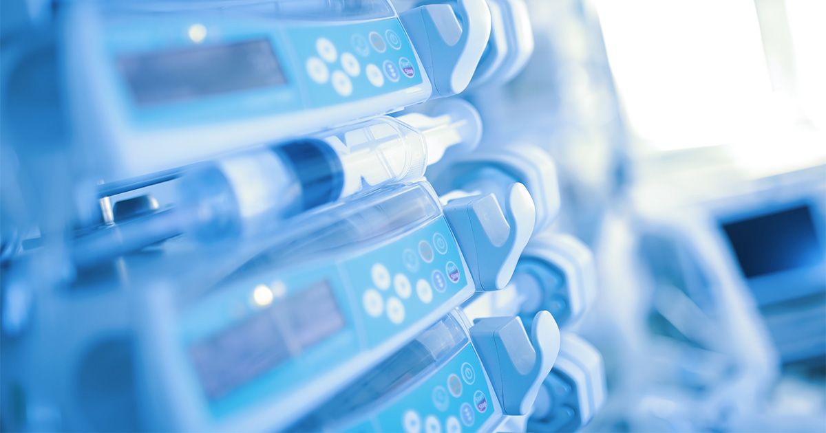 Image of medical device syringe pump in hospital room.