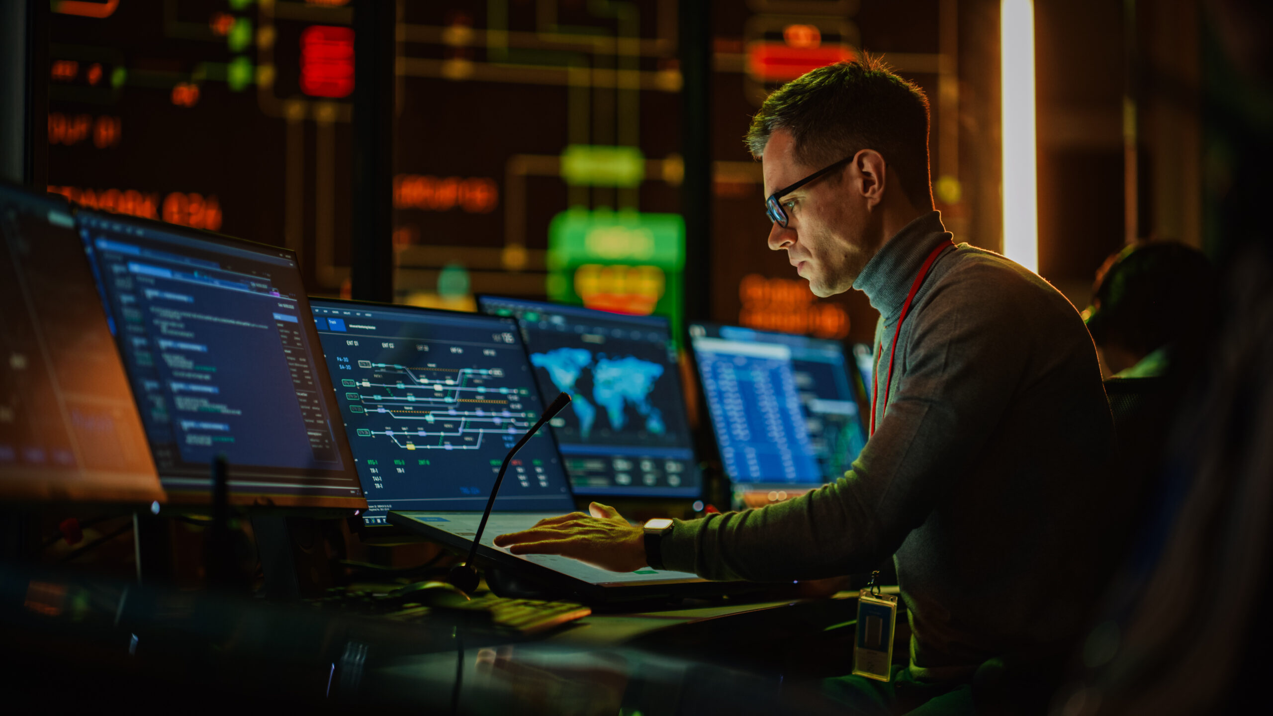 cybersecurity professional looking a computer screens in datacenter