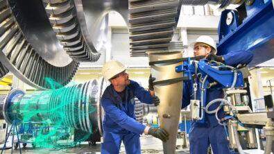 Two engineers in gas turbine manufacturing facility with digital overlay over turbine.