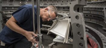 Manufacturing image shows man servicing an asset.