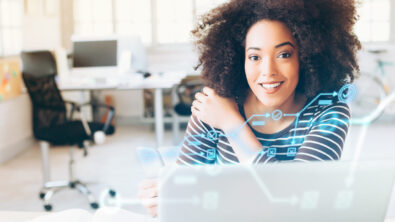 Woman smiling with a laptop in front of her in an office environment