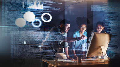 Shot of a group of programmers working together on a computer code at night