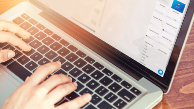 close-up image of hands on a laptop keyboard