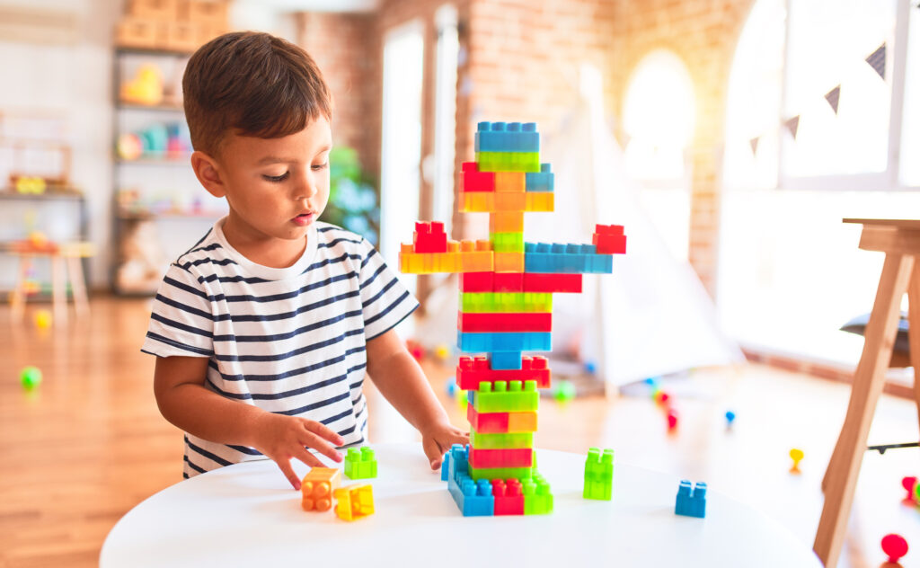 A young boy assembles Lego blocks