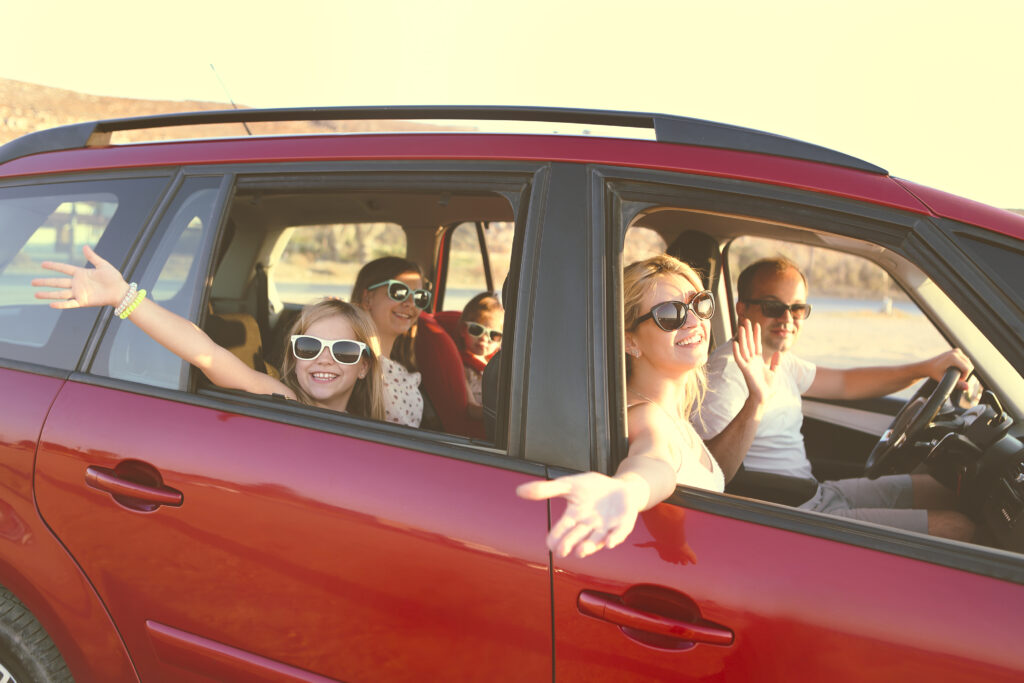 Large happy family riding in a red car