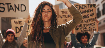 Woman leading a group of demonstrators on road.