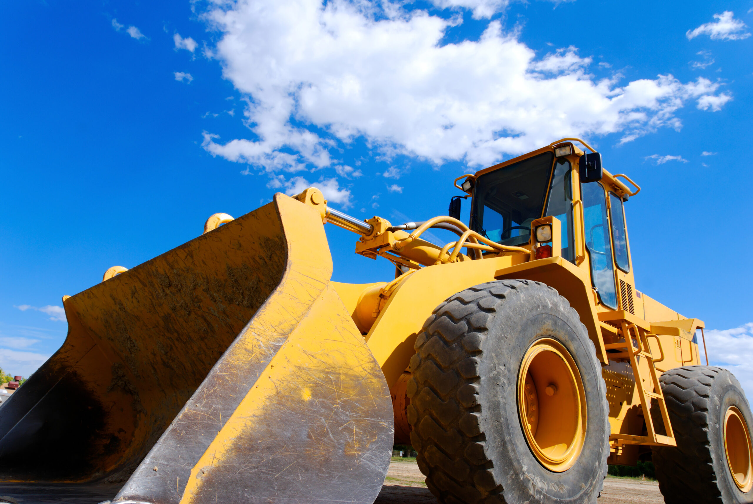 tractor with blue sky and clouds behind it