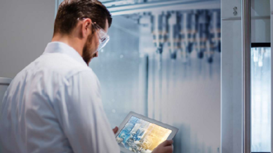 Man with goggles holding a tablet in a lab