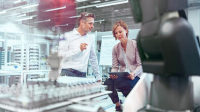 Businessman and businesswoman talking in a modern factory hall