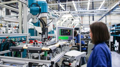 Woman in a factory working with electrical equipment and monitoring on a screen