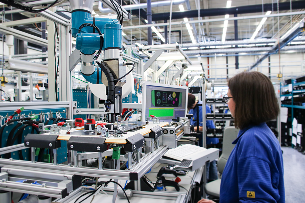 Woman in a factory working with electrical equipment and monitoring on a screen