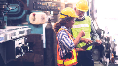 Professional Mechanical Engineer team Working on Personal Computer at Metal lathe industrial manufacturing factory. Engineer Operating lathe Machinery. Product quality Inspection