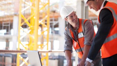 Construction workers using laptop on construction site