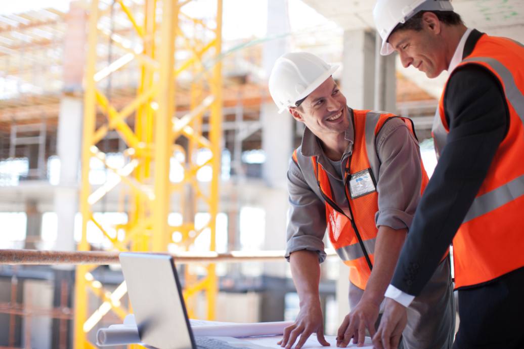 Construction workers using laptop on construction site