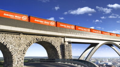 Freight train with containers crosses a bridge