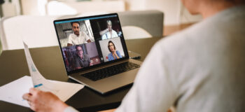 Group of business people working from home, having video conference. Businesswoman having a video call with her team over a laptop at home.